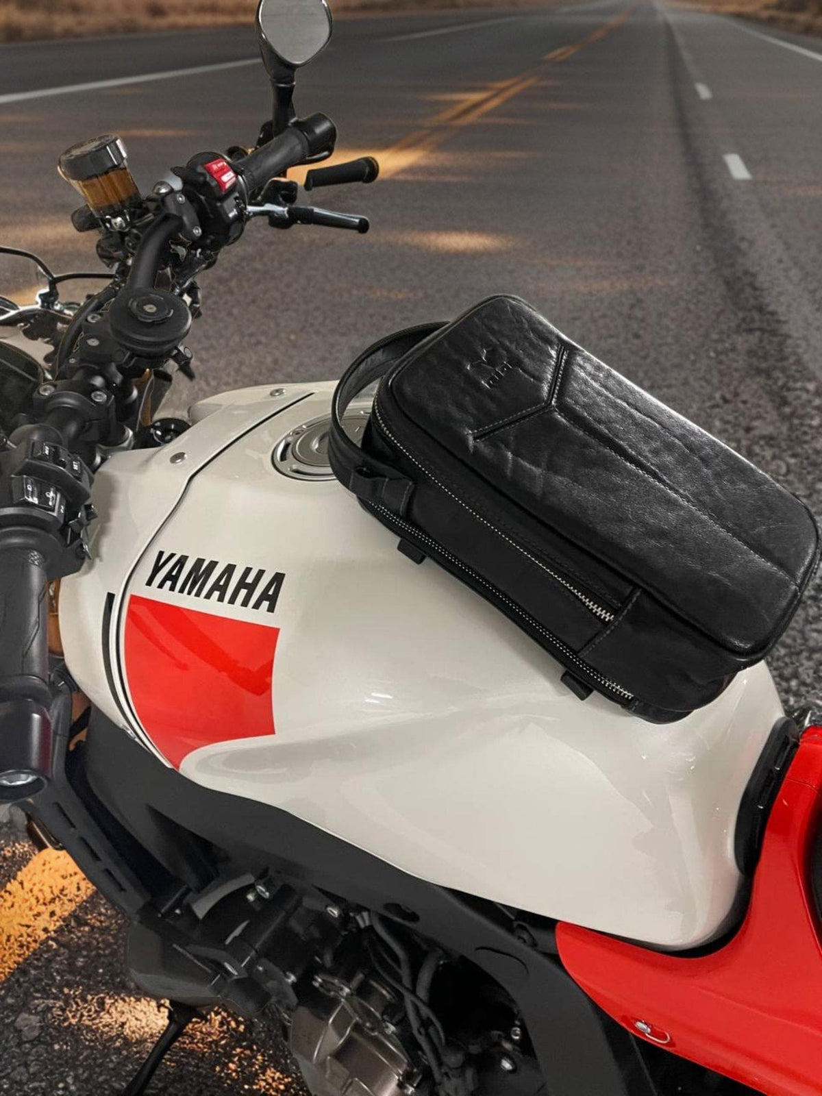 Black leather motorcycle tank bag with magnetic base on a motorcycle fuel tank